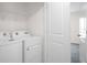 Bright laundry room features washer, dryer, and wire shelving for storage at 8471 Clearway Dr, Wildwood, FL 34785