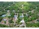 A landscape aerial view showcasing a gray home surrounded by dense trees and greenery at 9783 Sw 206Th Court Rd, Dunnellon, FL 34431