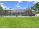 Backyard view of a screened-in lanai with a swimming pool and outdoor seating area at 9783 Sw 206Th Court Rd, Dunnellon, FL 34431