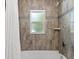 Bathtub with brown tile surround, rainfall shower head and accent tile at 9783 Sw 206Th Court Rd, Dunnellon, FL 34431