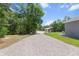Long, gravel driveway lined with trees leading to a large shed with plenty of parking at 9783 Sw 206Th Court Rd, Dunnellon, FL 34431