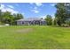 Spacious front yard view of a single-story home featuring an arched entryway, well-manicured lawn, and large windows at 9783 Sw 206Th Court Rd, Dunnellon, FL 34431