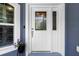 Elegant white front door with decorative glass, complementing the blue exterior and adding curb appeal at 9783 Sw 206Th Court Rd, Dunnellon, FL 34431