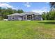 Charming gray home featuring a manicured front yard, screened entryway, and stone accents at 9783 Sw 206Th Court Rd, Dunnellon, FL 34431