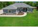 An aerial view of a gray home featuring a well-maintained lawn and landscaped front at 9783 Sw 206Th Court Rd, Dunnellon, FL 34431