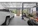 View of vehicles, lift, and other equipment inside a large garage or shed with concrete floors at 9783 Sw 206Th Court Rd, Dunnellon, FL 34431
