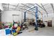 View of vehicles, lift, and other equipment inside a large garage or shed with concrete floors at 9783 Sw 206Th Court Rd, Dunnellon, FL 34431