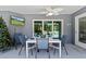 Covered patio with a ceiling fan, dining table and seating, as well as a wall-mounted television at 9783 Sw 206Th Court Rd, Dunnellon, FL 34431