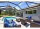 Enclosed pool with an adjacent seating area, dining space, and comfortable patio furniture at 9783 Sw 206Th Court Rd, Dunnellon, FL 34431