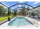 Enclosed pool with clear blue water and an adjacent seating area, offering a luxurious outdoor experience at 9783 Sw 206Th Court Rd, Dunnellon, FL 34431