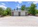 Detached two-bay garage featuring a concrete slab, gray exterior, and white doors at 9783 Sw 206Th Court Rd, Dunnellon, FL 34431