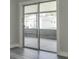 Bedroom with sliding glass doors leading to an outdoor patio, showcasing modern flooring and bright light at 10859 William And Mary Ct, Orlando, FL 32821