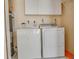 Well-equipped laundry room with washer, dryer, storage cabinets, and water heater at 10859 William And Mary Ct, Orlando, FL 32821