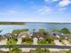 Aerial view featuring a lakefront house with lush landscaping and mature trees at 1382 Heritage Landings Dr, Lakeland, FL 33805