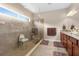 Accessible bathroom with a tiled shower, shower seat, and dual sink vanity with granite countertops at 1382 Heritage Landings Dr, Lakeland, FL 33805