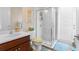 Well-lit bathroom featuring a glass-enclosed shower, cherry vanity, white toilet, and coordinating accessories at 1382 Heritage Landings Dr, Lakeland, FL 33805