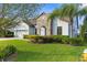 Charming home with a well-manicured lawn, stone accents, and mature landscaping creates a welcoming curb appeal at 1382 Heritage Landings Dr, Lakeland, FL 33805
