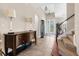 Inviting foyer with elegant staircase, decorative lighting, console table, and tile flooring leading to a glass front door at 1382 Heritage Landings Dr, Lakeland, FL 33805