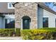 Close-up of a home's elegant front entrance with stone accents, a decorative door, and manicured landscaping at 1382 Heritage Landings Dr, Lakeland, FL 33805