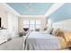 Spacious main bedroom features a blue accent ceiling, a ceiling fan, and lots of natural light at 1382 Heritage Landings Dr, Lakeland, FL 33805