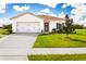 Charming single-story home with a well-manicured lawn and attached two-car garage on a sunny day at 1538 Landon Ln, Haines City, FL 33844