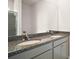 Bathroom featuring double sinks, gray cabinets, granite countertops, and a large mirror at 4106 Nw 44 Cir, Ocala, FL 34482