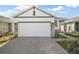 Spacious two-car garage with a brick-paved driveway and manicured landscaping at 4106 Nw 44 Cir, Ocala, FL 34482