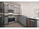 Modern kitchen features stainless steel appliances, gray cabinets, and granite countertops at 4106 Nw 44 Cir, Ocala, FL 34482