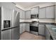 Modern kitchen featuring gray cabinets, granite countertops, and stainless steel appliances at 4106 Nw 44 Cir, Ocala, FL 34482