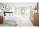 Bedroom featuring a bed with white linens, botanical wall art, wood dresser and bright windows at 420 Harvard Ct, Dundee, FL 33838
