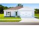 Charming single-story home featuring a colorful front door and well-manicured lawn at 420 Harvard Ct, Dundee, FL 33838
