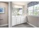 A bathroom featuring double sinks, white cabinets, and a large mirror with modern lighting at 480 Crossings Ave, St Cloud, FL 34771