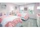 Cozy bedroom featuring twin beds with pink bedding, matching nightstands, and lots of natural light at 480 Crossings Ave, St Cloud, FL 34771