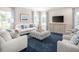 Comfortable living room with soft seating, a large TV, and ample natural light from the many windows at 480 Crossings Ave, St Cloud, FL 34771