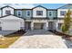 Charming multi-tone two-story townhome featuring a brick driveway, covered entryway, and attached garage at 1100 Desert Candle Dr, Ocoee, FL 34761