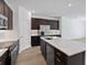Modern kitchen with stainless steel appliances, a large island, and dark cabinets at 1126 Desert Candle Dr, Ocoee, FL 34761