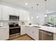 Modern kitchen with stainless steel appliances, white cabinets, and quartz countertops, ideal for cooking and entertaining at 3307 Grande Heron Dr, St Cloud, FL 34773