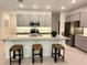 Modern kitchen boasts stainless steel appliances, granite countertops, gray cabinets, and a stylish center island with barstool seating at 5240 Luisa Ct, St Cloud, FL 34771