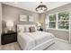 Serene bedroom with a plush bed, decorative lighting, and a large window offering natural light at 5269 Luisa Ct, St Cloud, FL 34771