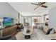 Open-concept living room with modern furnishings, a ceiling fan, and seamless flow to the dining and kitchen areas at 5269 Luisa Ct, St Cloud, FL 34771
