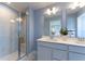 A well-lit bathroom featuring a walk-in shower, double sink vanity, quartz countertop, and modern fixtures at 554 Highfalls Ave, Debary, FL 32713