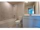 A well-lit bathroom features a tub, shower, toilet, and single sink vanity with a large mirror at 554 Highfalls Ave, Debary, FL 32713