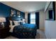 A bedroom featuring blue walls, a window, and a comfortable bed with a unique comforter and dark wood furniture at 554 Highfalls Ave, Debary, FL 32713