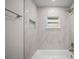 Modern bathroom featuring marble-tiled walls, a soaking tub, and a shower with rainfall showerhead at 2404 Needle Palm Dr, Edgewater, FL 32141