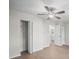 Bright bedroom featuring a ceiling fan, a closet, an entry door and wood-look laminate flooring at 2404 Needle Palm Dr, Edgewater, FL 32141