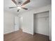 Spacious bedroom with ceiling fan, light-colored walls, wood-look floors, and a closet at 2404 Needle Palm Dr, Edgewater, FL 32141