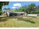A single-story home with stone accents, a two car garage, trimmed landscaping, and a wide front lawn at 2404 Needle Palm Dr, Edgewater, FL 32141
