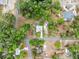 Birds eye view of home in a charming community surrounded by lush greenery, showing driveway and surrounding homes at 1161 Cr 443, Lake Panasoffkee, FL 33538