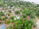 Aerial view of the residence amidst lush trees, offering a glimpse of the charming community and nearby lake at 1161 Cr 443, Lake Panasoffkee, FL 33538