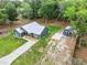 Aerial view showing the home's metal roof and new storage shed in a naturally wooded backyard at 1161 Cr 443, Lake Panasoffkee, FL 33538